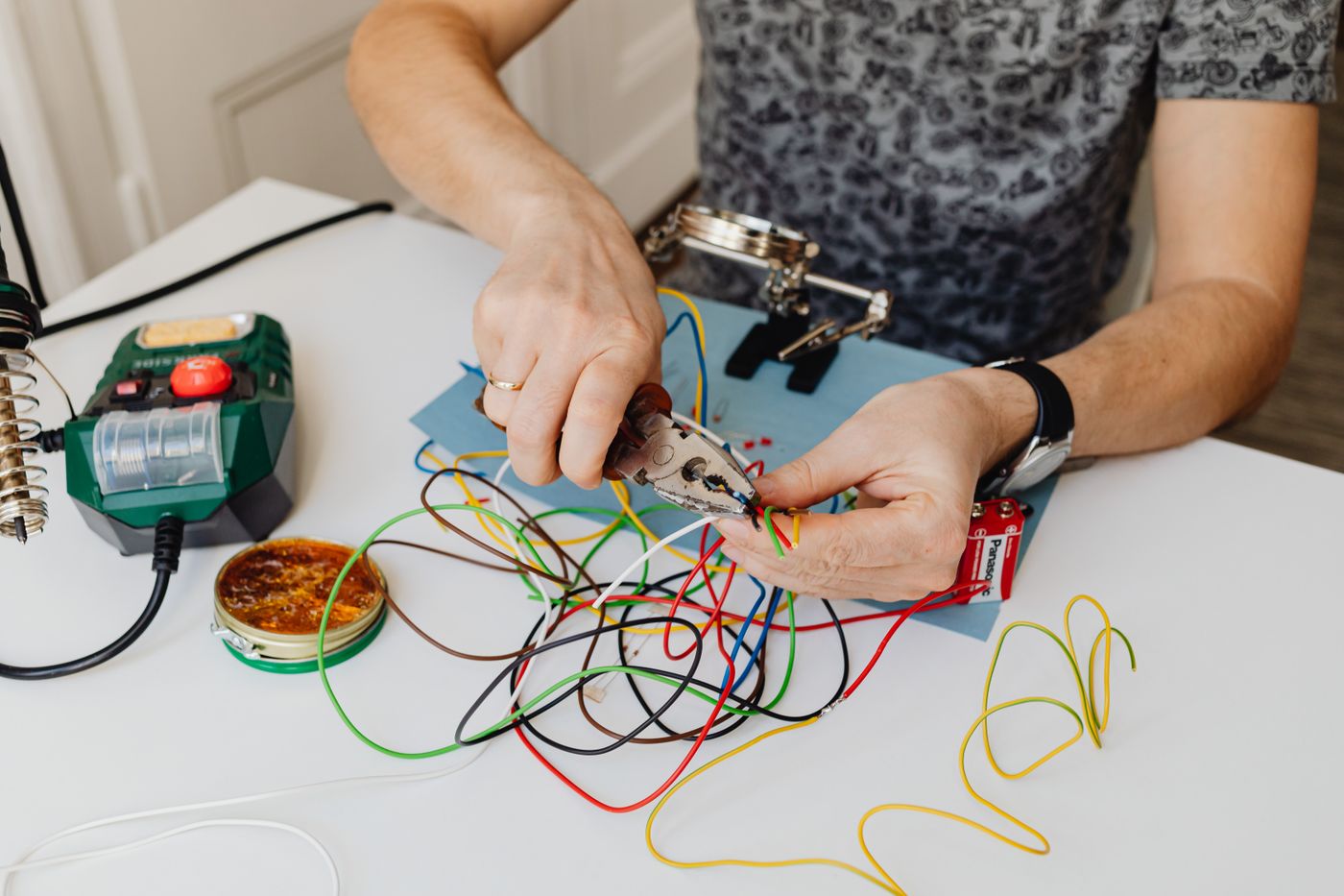 An electrician stripping and terminating colour-coded wiring